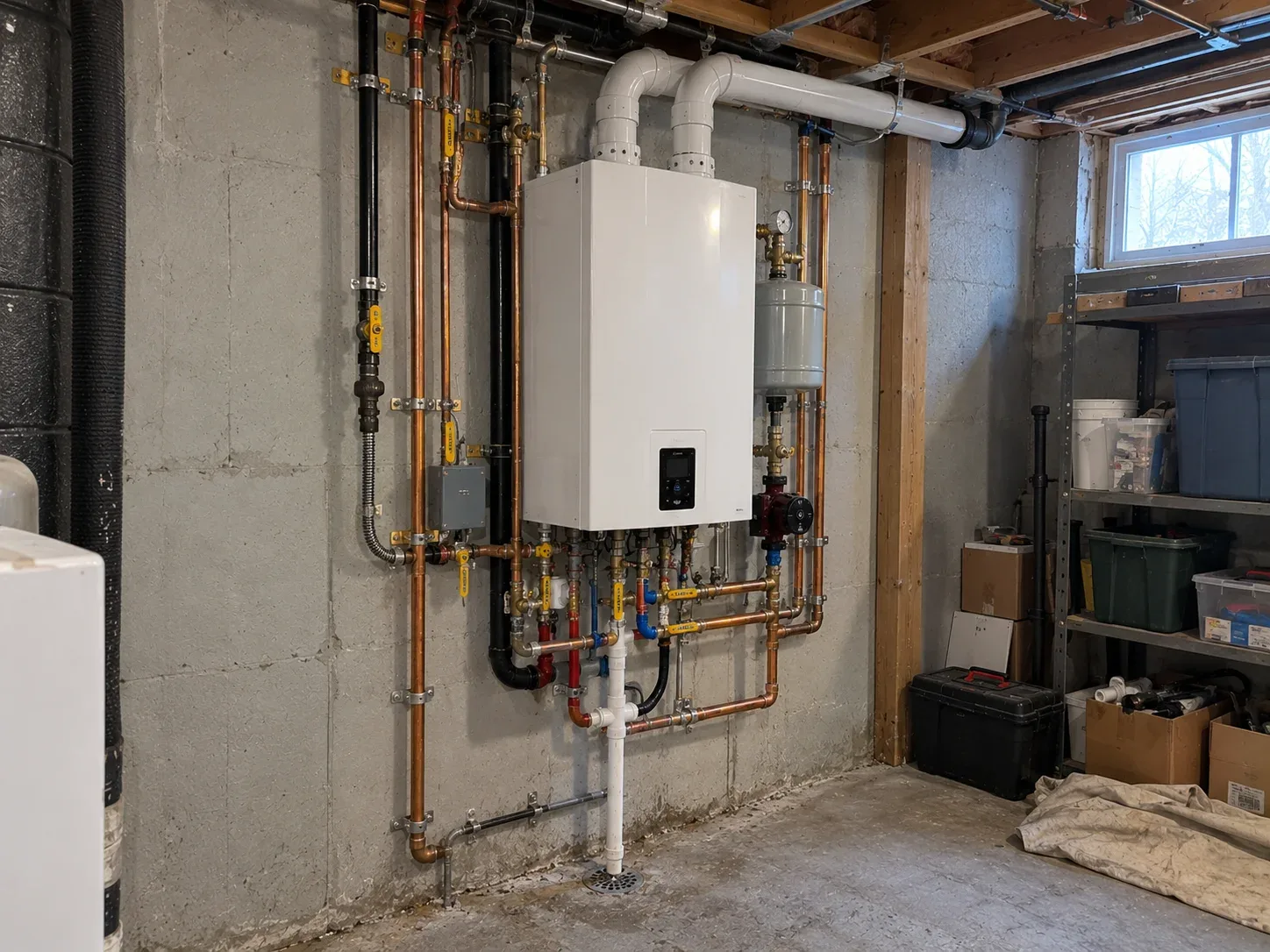 New wall-mounted combi boiler with copper heating and water connections installed in a Kitchener basement